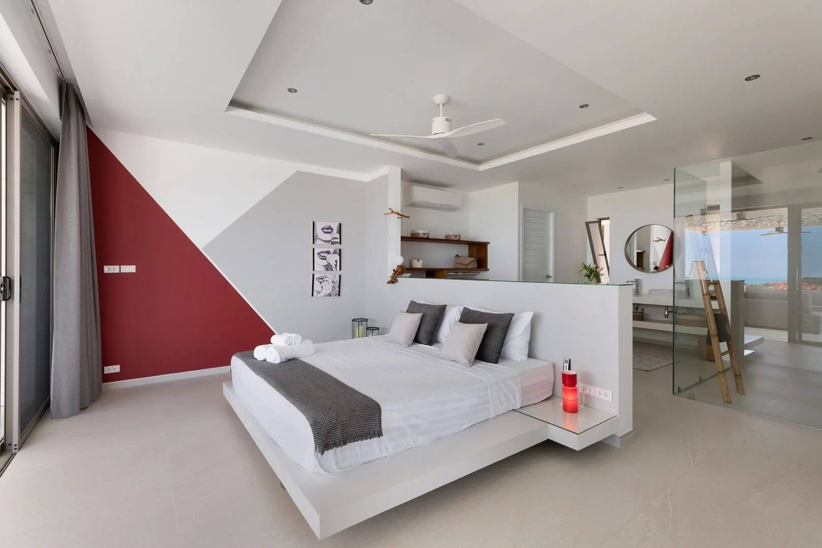 Suite two — a deep red feature wall and an open en-suite bathroom behind glass.