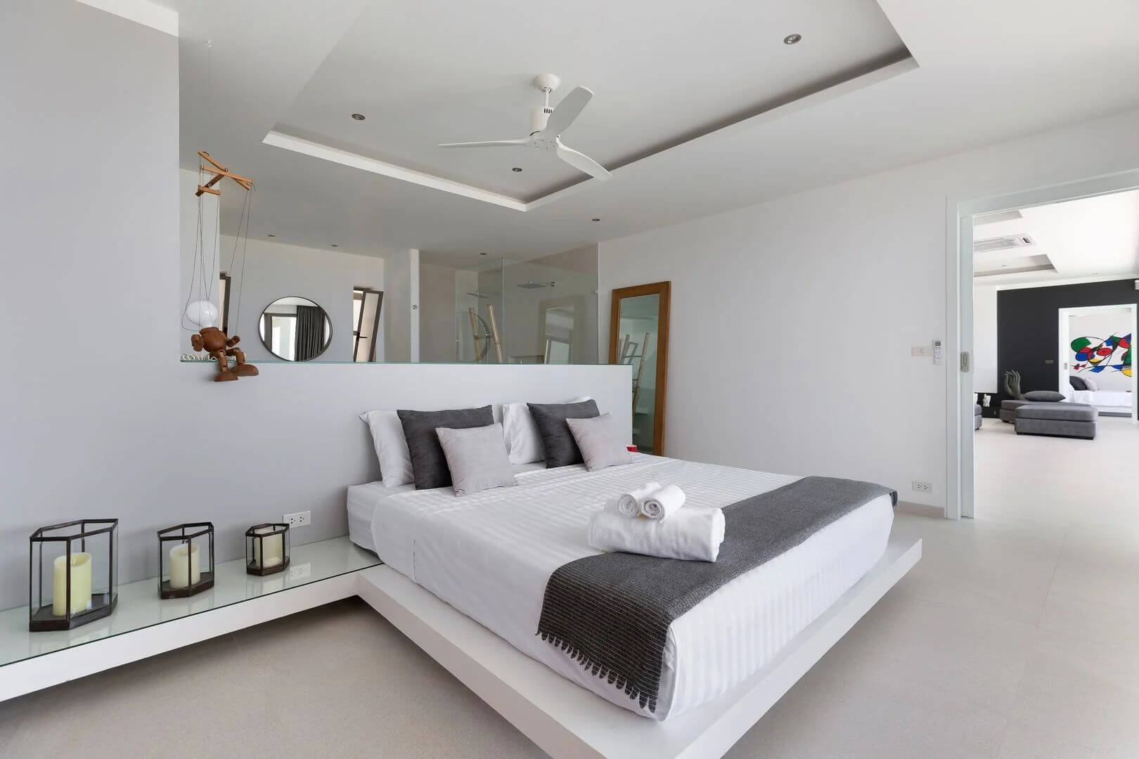 Suite three — an all-white room with candle lanterns and a floating king bed.